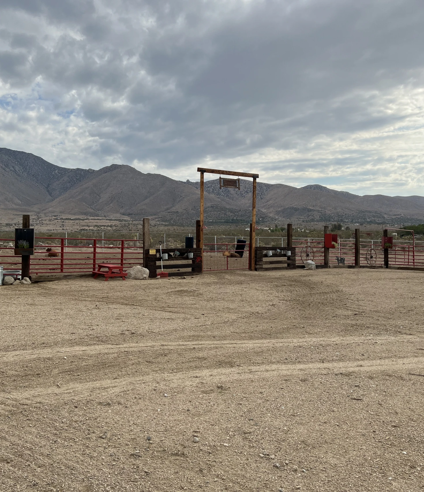 Desert landscape with fenced area and mountains.